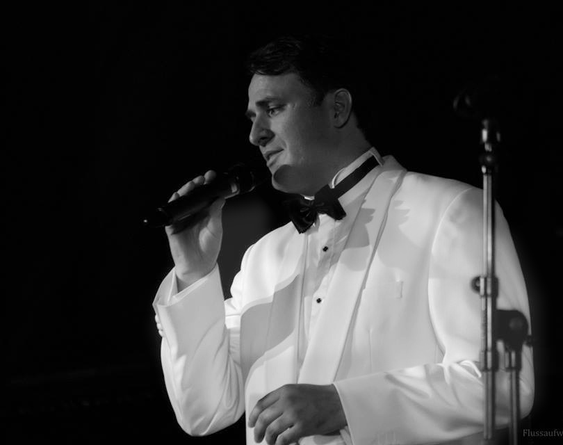 Jeffrey Ocean performing in a white dinner jacket